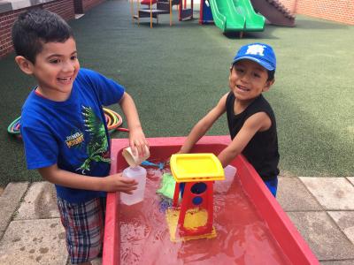 photo of students playing at water tables