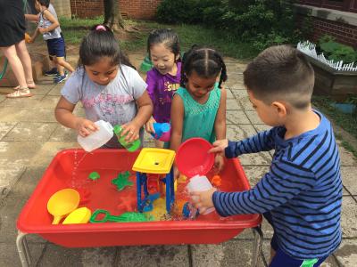 photo of students playing at water tables